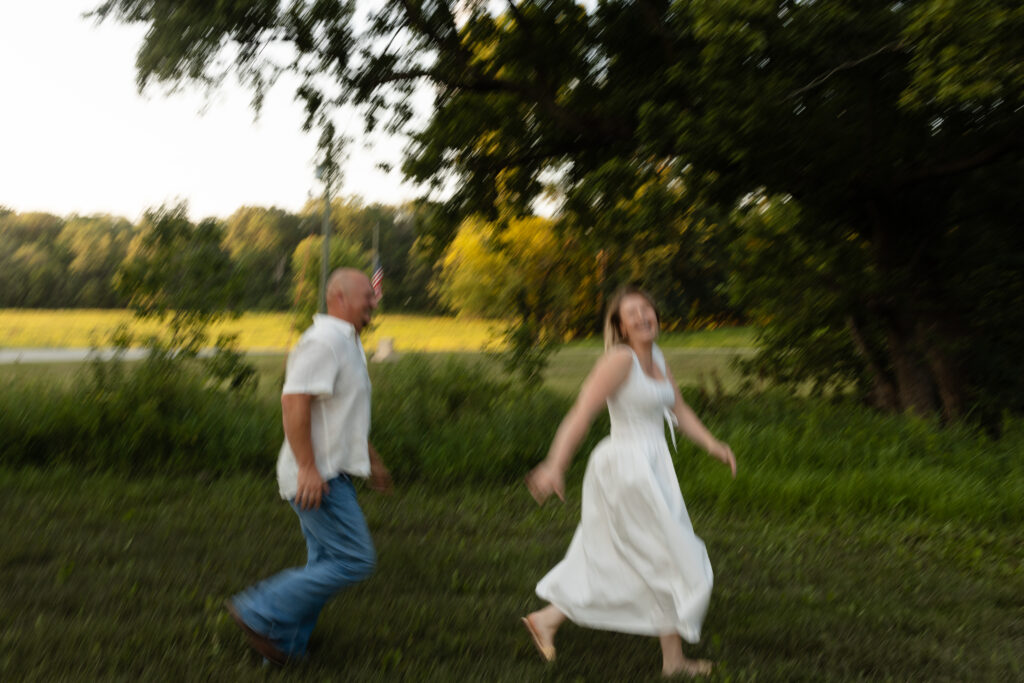 Blurry picture of couple running around during an engagement session at Wildcat Bluff Recreation Area in Vinton, IA.