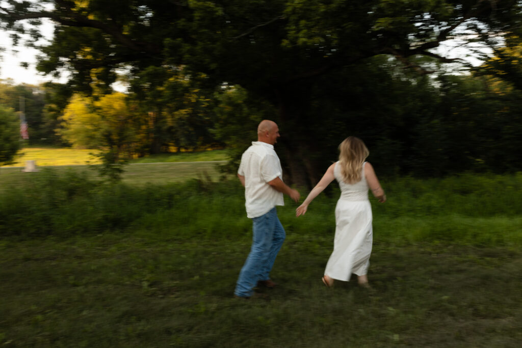 Blurry picture of couple running around during an engagement session at Wildcat Bluff Recreation Area in Vinton, IA.