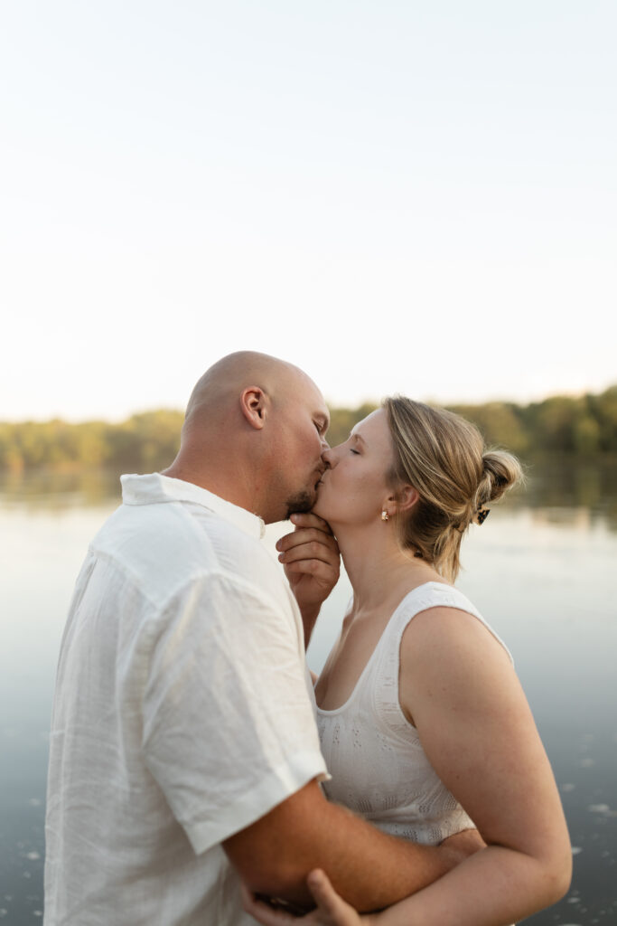 Couple kissing in the water during an engagement session at Wildcat Bluff Recreation Area in Vinton, IA.