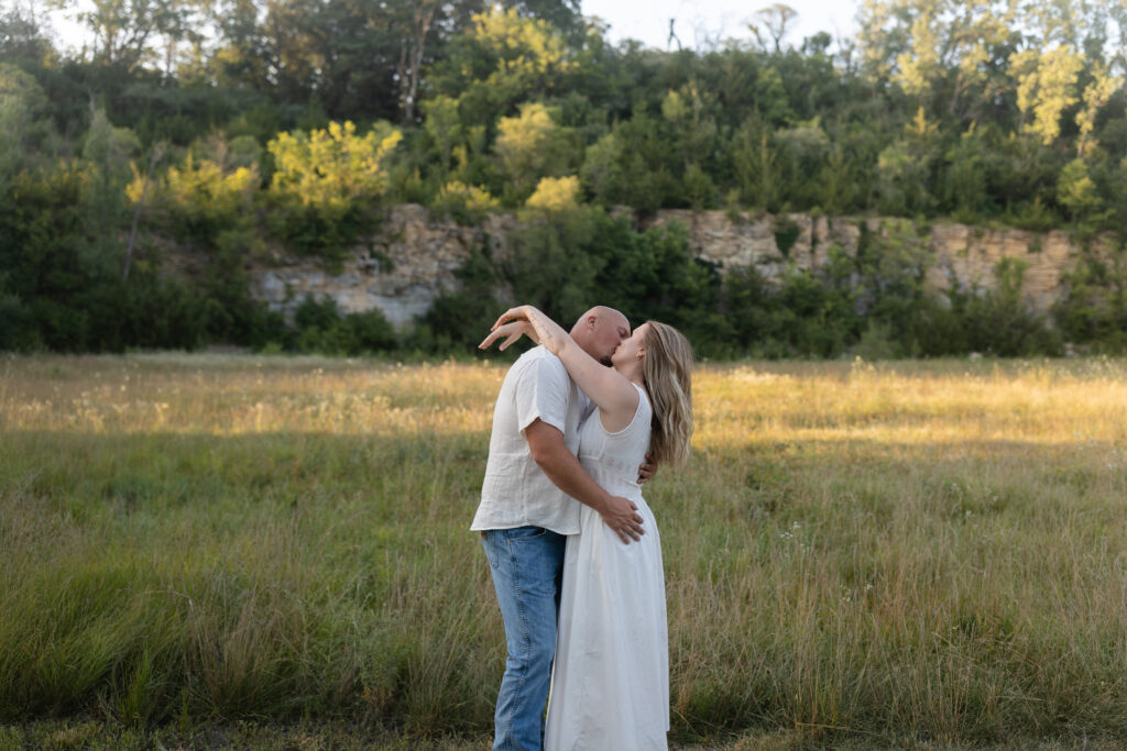 Couple kissing in the field at Wildcat Bluff Recreation Area in Vinton, IA.