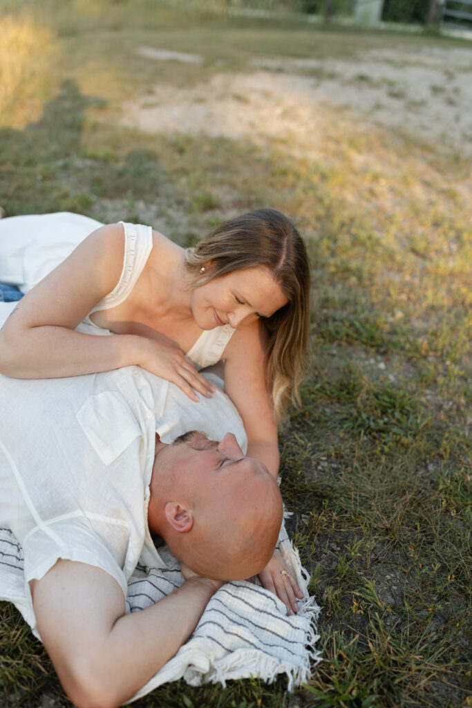 Couple cuddling on the ground at Wildcat Bluff Recreation Area in Vinton, IA.
